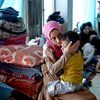 Niña de ocho años sostiene a su hermano, de tres años, en la escuela del pueblo de Algosh, donde su familia ampliada ha encontrado albergue después de huir de Mosul.