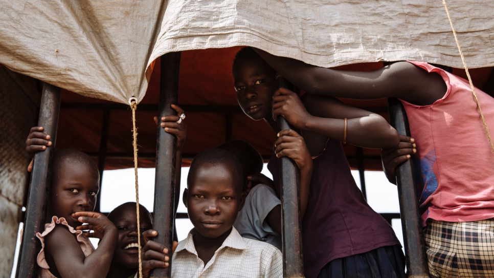 South Sudanese refugees look out of a truck before being transported to the recently established Imvepi settlement, at the Imvepi Reception Centre, Arua District, Northern Region, Uganda. The Imvepi settlement was opened in February 2017 to deal with the large influx of refugees from South Sudan.