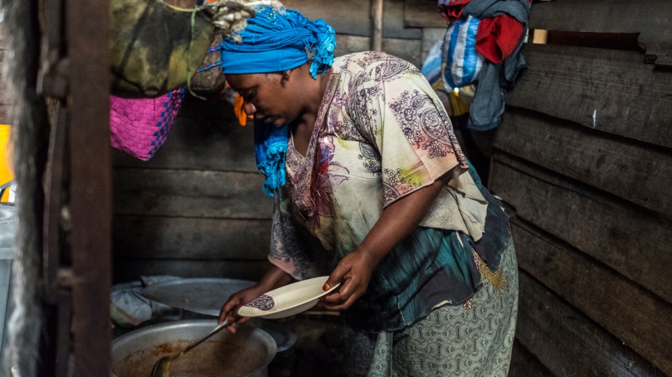 Odette prépare des assiettes dans la cuisine de son restaurant à Goma. 