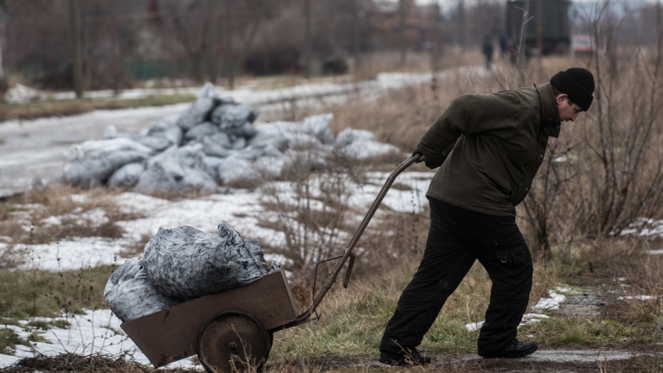 Un homme tire une charrette de charbon vers sa maison dans le village de Luhanske, Donetsk. 