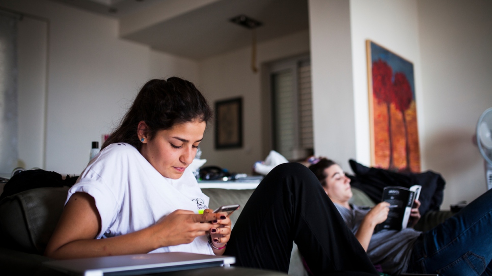 Sarah checks her phone after a day of volunteering.