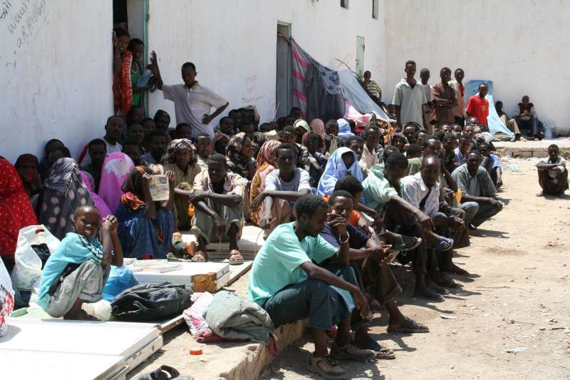 Migrants and refugees sit outside at the Obock detention centre, which was built to hold 20 detainees but now holds more than 200 people.