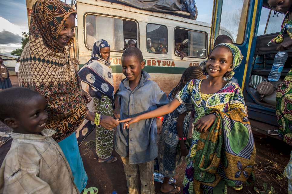 Cameroon / CAR refugees / Madina has a big smile on her face when she finally finds her older sister, Ramatou, at her descent from the bus that brought her to Mbile refugee camp from Gbiti, Cameroon/CAR border. Madina had spent two months walking with her two brothers in the bush. She did not know whether she would see her sister again/ UNHCR / F.Noy / May 2014