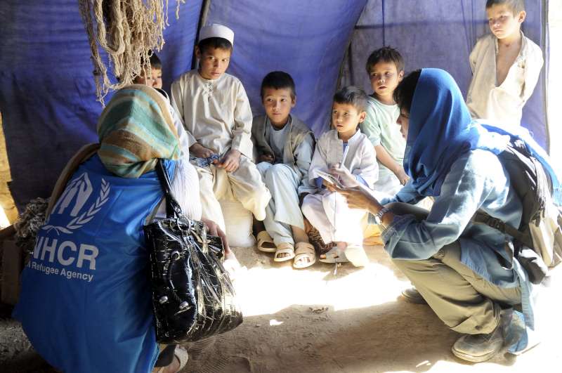 Afghanistan / returnees / Farishta and Vivian Tan from UNHCR speak with UNHCR returnees Ibrahim (white cap) and Sayed Sikandar (on his right), at  Qaleen Bafan (Carpet Weavers) village, Nahreshahi District, Balkh Province, Afghanistan, on Wednesday, October 8, 2008.  The family of Mr. Shafi are ethnic Turkmen known for their carpet weaving skills. / October 2008