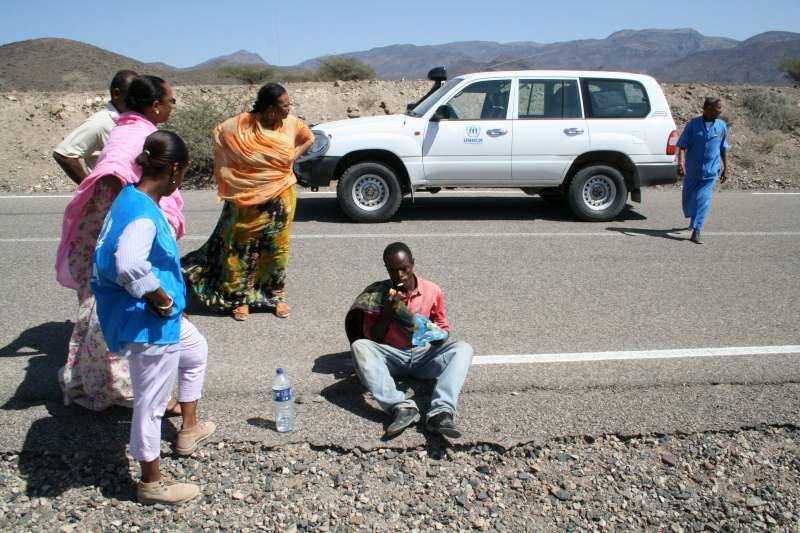 Staff from UNHCR and the Djibouti Refugee Commission talk with an exhausted Ethiopian man, who has travelled for days and gone without food or water in order to get to Djibouti.