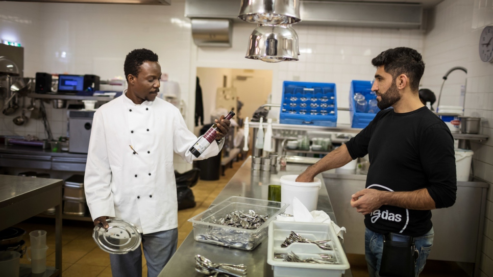 Segun talks to Sherahmad Razi in the kitchen.