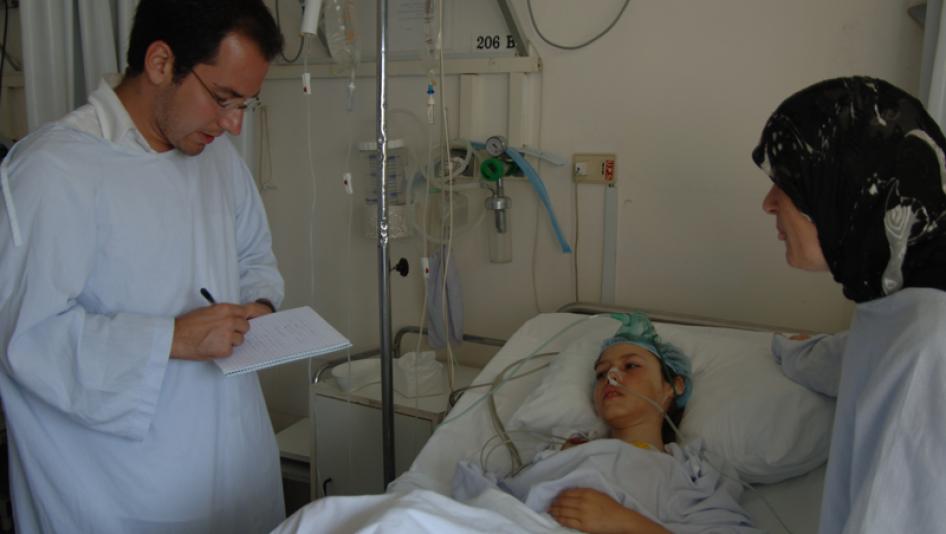 Nadim Houry (left) interviews a civilian casualty in Lebanon. 