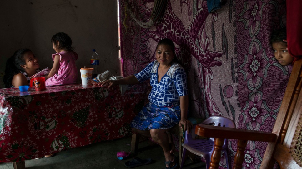 Ana sits with her teenage niece and two granddaughters.