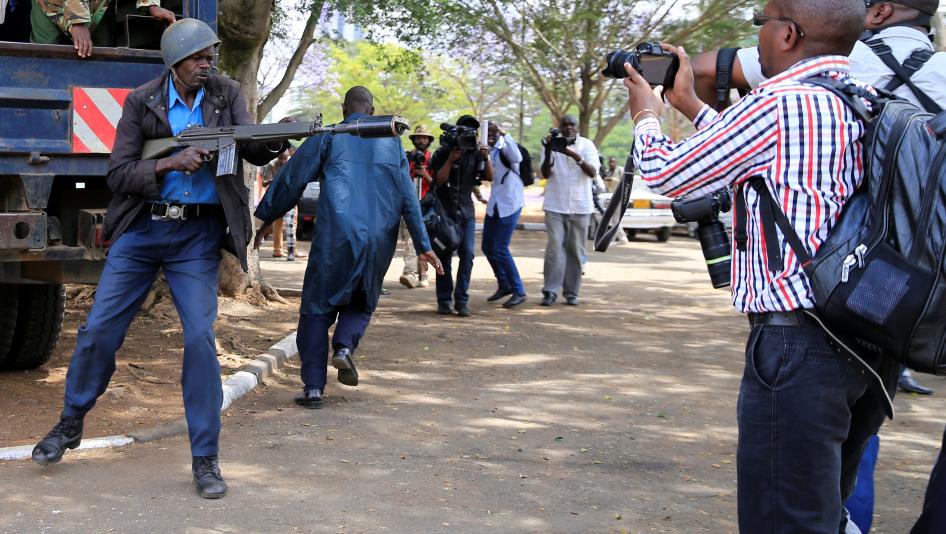 An anti-riot police officer aims a teargas canister while journalists cover an anti-corruption protest in Kenya's capital, Nairobi. November 3, 2016. 