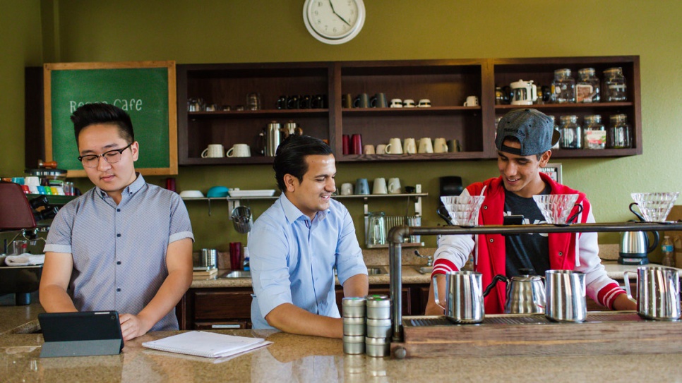 Samiullah Haidari (centre), from Afghanistan, speaks with other barista trainees at a course organized by the 1951 Coffee Company.