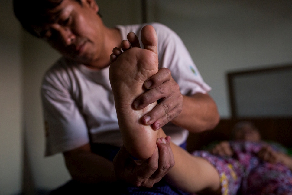 Thant massages his mother-in-law's paralyzed foot.