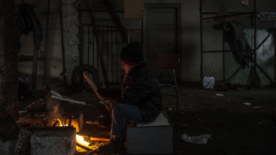 Aziz Jabarkheil, huit ans, assis près d'un feu, tente de se réchauffer par des températures négatives à Belgrade. Aziz n'a pas dormi dans un vrai lit depuis près d'un an. 