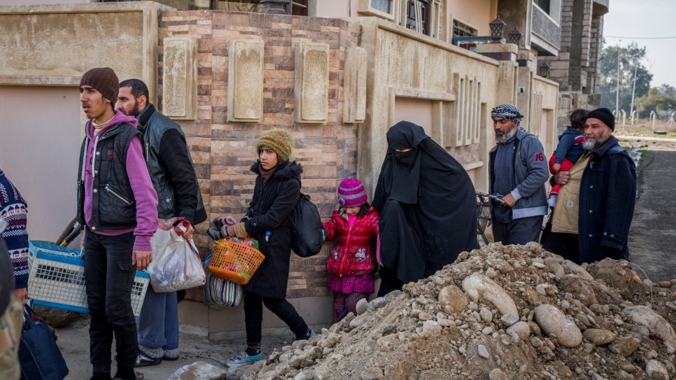 Des familles iraquiennes fuient le quartier d'Al Thaqafa peu de temps après sa libération par les militaires iraquiens. 