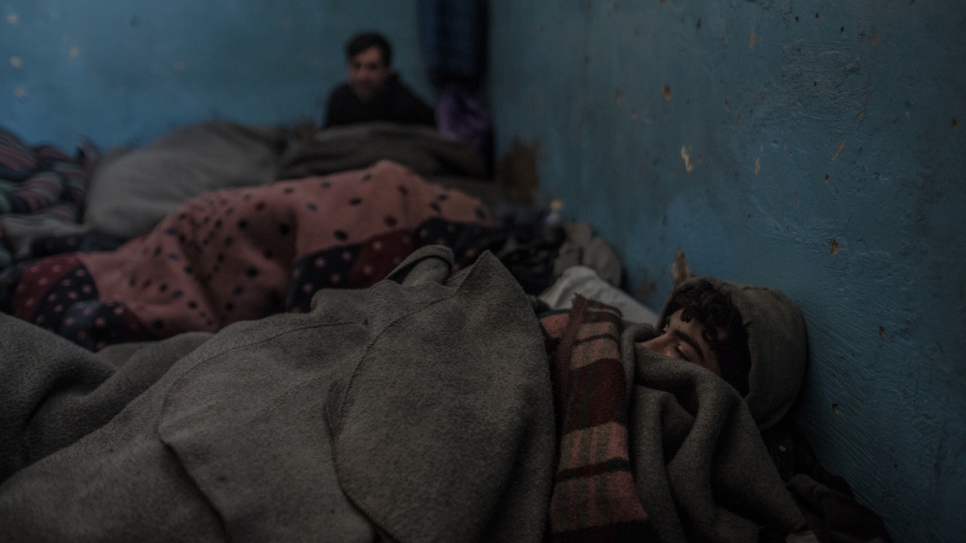 Les réfugiés afghans se réveillent après avoir passé une nuit sous des couvertures dans un froid glacial dans un entrepôt de Belgrade. 