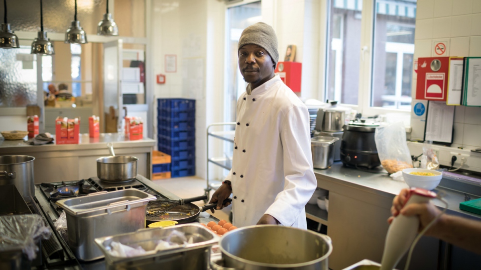 Segun Prince, 45, from Benin, cooks breakfast.