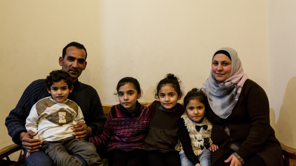Mohamed and Maysoun pose for a portrait with their children, (left-to-right) Baraa, Alissar, Limar, and Elian inside the house given to the family by UNHCR.