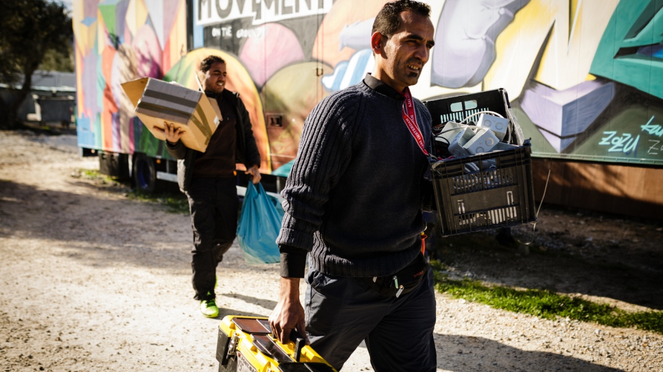 Mohamed (right) and his brother Mofeed, carry their tools to a prefabricated house at Kara Tepe accommodation facility where they will install the electrics.