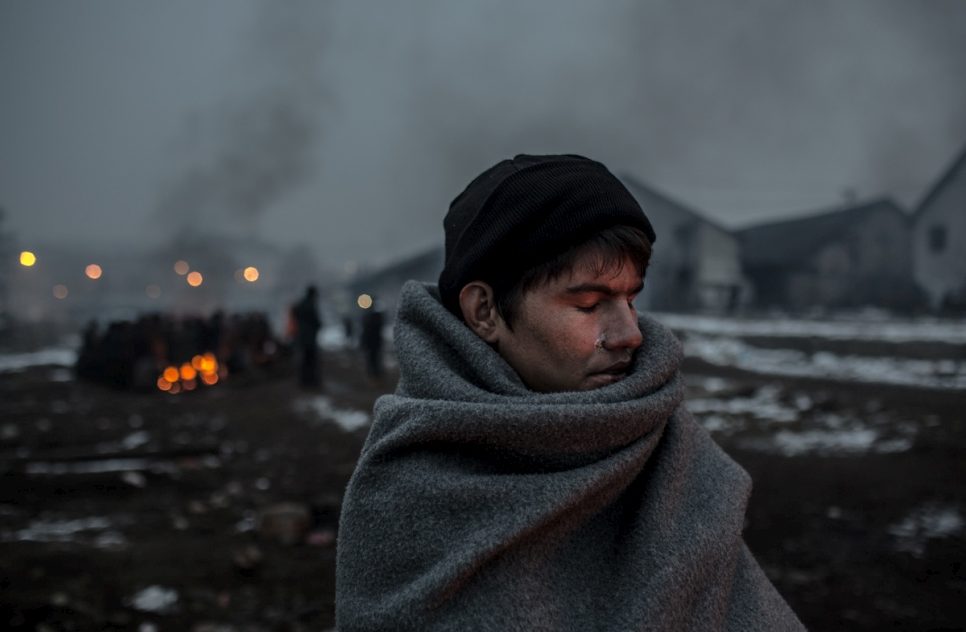 Hazrat, 16, an Afghan refugee, warms himself at a fire behind the main train station of Belgrade. © UNHCR/Daniel Etter