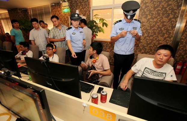 Police check the ID cards of netizens at an internet cafe in Shandong, China, in a file photo.