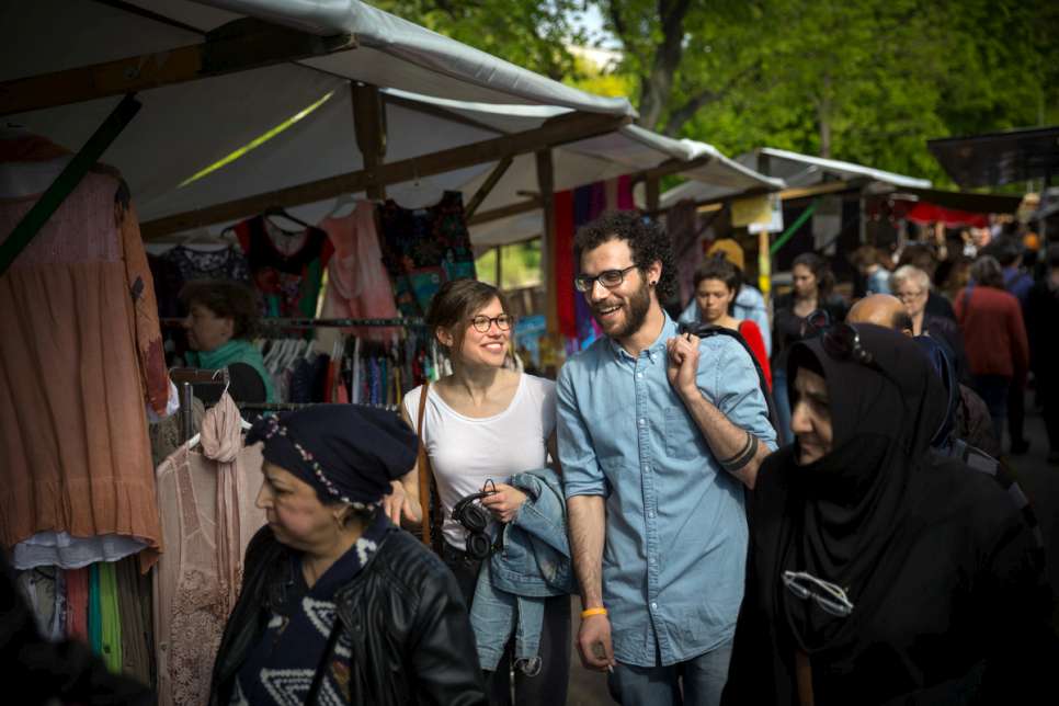 Ramy, a law student who fled war-torn Syria, and new friend Antonia walk through the Turkish weekly market in Berlin.