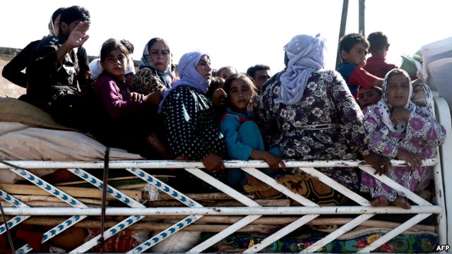 Syrians cross a checkpoint outside the northwestern Syrian city of Afrin, on the Syria-Turkey border, on August 23.