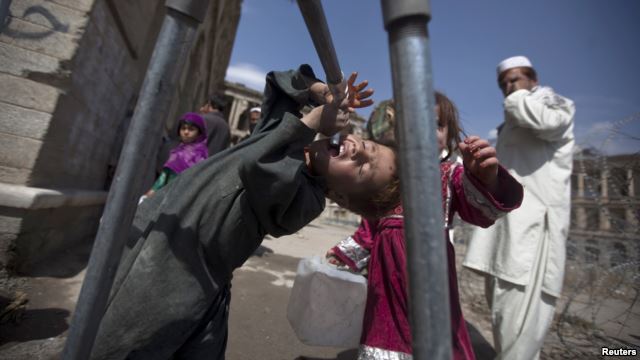 A Kuchi boy tries to drink water in front of the ruins of Darul Aman palace in Kabul.