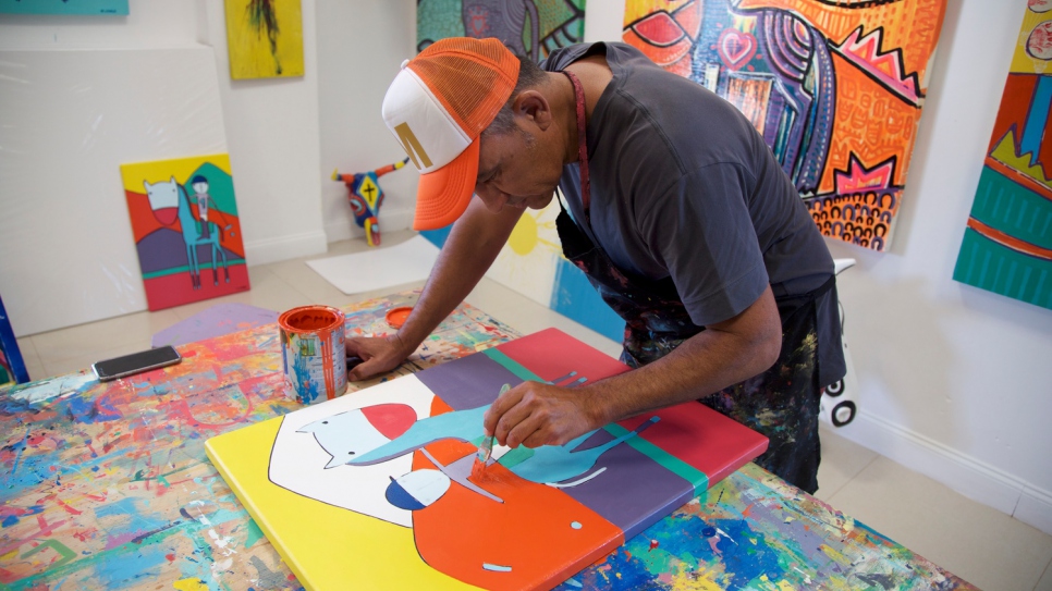 Mario works on a painting in his workshop in San Luis. 