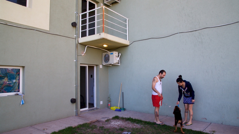 Majd and Lana play with their puppy, given to them by the governor of San Luis Alberto Rodríguez Saá, outside their new apartment.