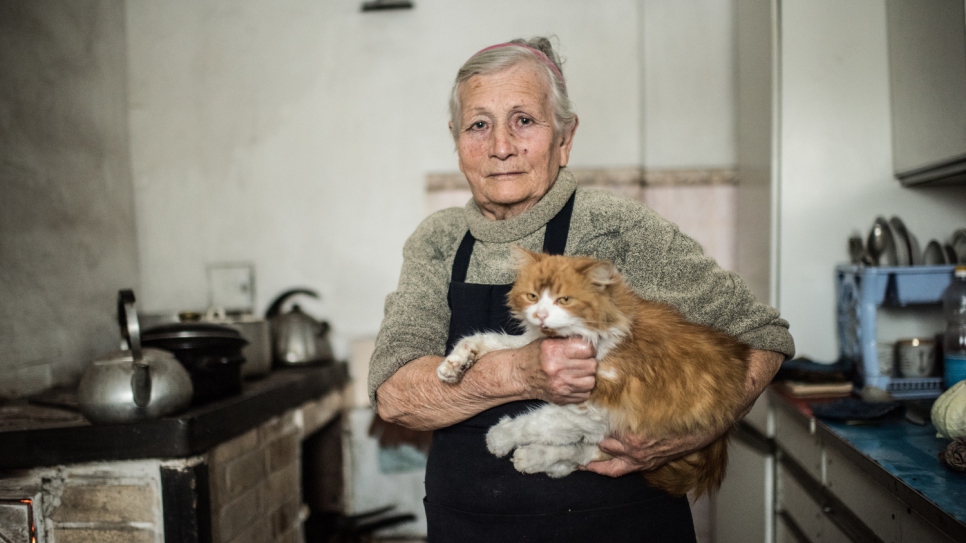 Nina, 62, looks out of the window of her house in the village of Luhanske, Donetsk.