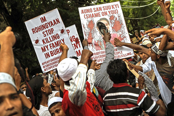 Ethnic Rohingya Muslim refugees use a shoe to hit a placard with a portrait of Myanmar State Counselor Aung San Suu Kyi during a protest against the persecution of Myanmar's Rohingya Muslims in Kuala Lumpur, Malaysia, Nov. 25, 2016.