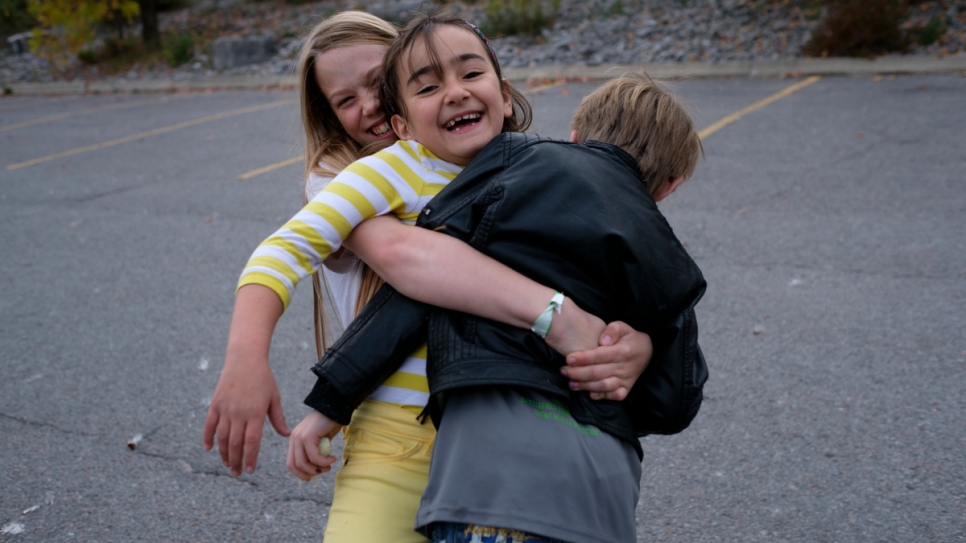 Bayan joue avec ses nouveaux amis dans un parc à Peterborough. 