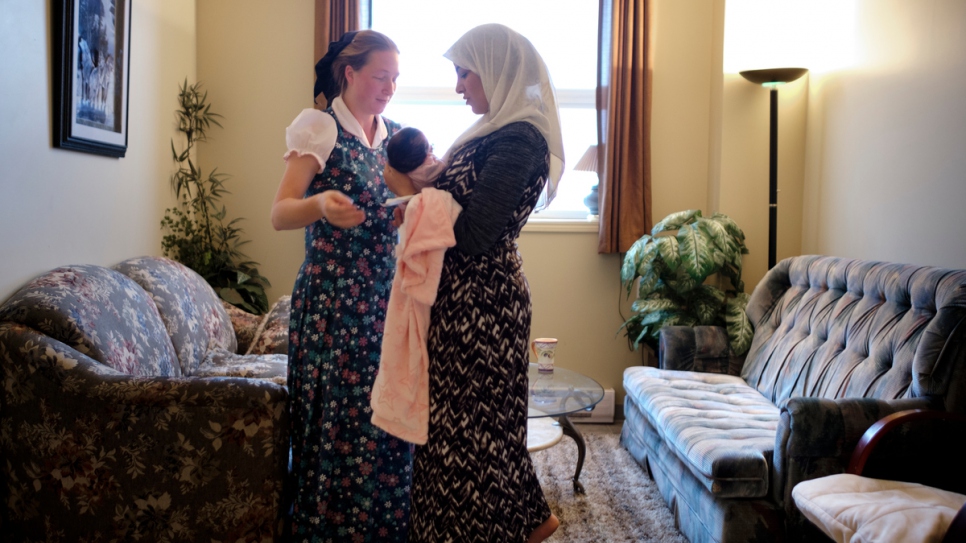 Elaine Hofer (à gauche) aide Najwa Hussein à prendre soin de son nouveau-né, Janna, une petite fille. 