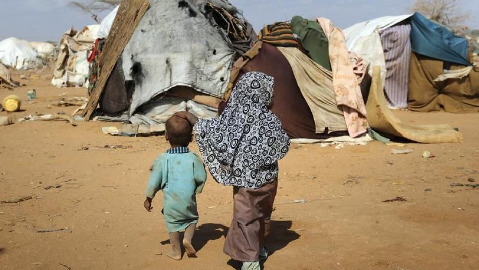 Children walk together amongst makeshift homes, or "tukuls", in the outskirts of Dagahaley settlement at Kenya's Dadaab Refugee Camp, August 31, 2011.