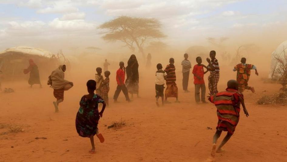 Newly-arrived refugees run away from a cloud of dust at the Dagahaley refugee camp in Dadaab, near Kenya's border with Somalia in Garissa County, Kenya, July 16, 2011.
