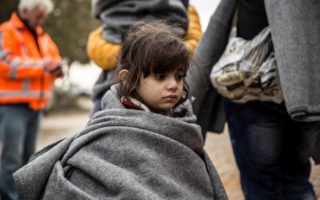 A young refugee girl cries as she waits for a bus to take her from the shore to a registration centre on the Greek island of Lesvos in this January 2016 file photo.  © UNHCR/Hereward Holland