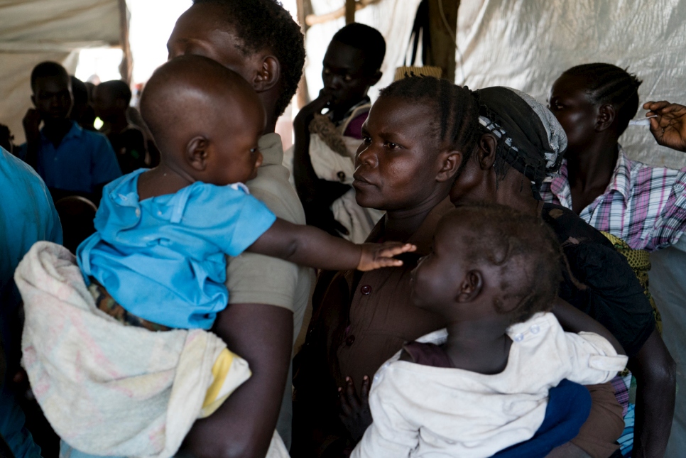 Sidah Hawa queues with her children at Kuluba transit centre to get registered and have her children vaccinated. © UNHCR/Michele Sibiloni