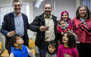 High Commissioner Filippo Grandi and IRCC Deputy Minister Anita Bigus greet the Halo Family at the Head Office of the Catholic Centre for Immigrants in downtown Ottawa.  From left to right: High Commissioner Filippo Grandi, Ferhan Halo, Malva Halo holding baby Sehmus, Deputy Minister Anita Bigus and the Halo children.  @ UNHCR/G. Capriotti