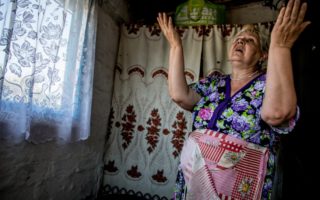 Natalia Golovchenko, 59, describes what she lived through during the 2014 conflict inside her family house in the village of Khryaschevatoye. © UNHCR/Petr Shelomovskiy