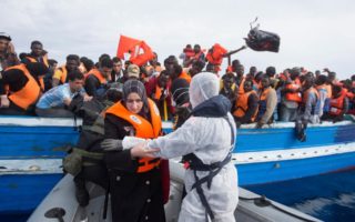 People trying to cross from north Africa to Europe on an overloaded fishing boat are rescued from the Mediterranean Sea by the Italian Navy, June 5, 2014.   © Massimo Sestini for the Italian Navy