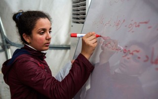 Iva writes the following week's schedule for her classmates at the end of a class in Suruç camp, Turkey.