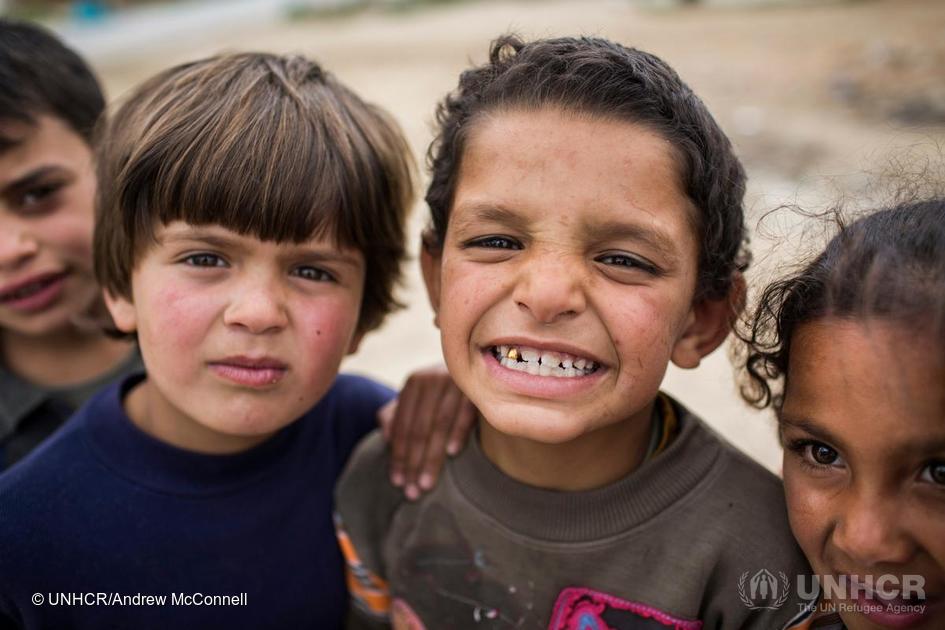 Omar, 7, shows off his gold tooth outside his shelter in the informal tented settlement of Fayda, in the Bekaa Valley, Lebanon