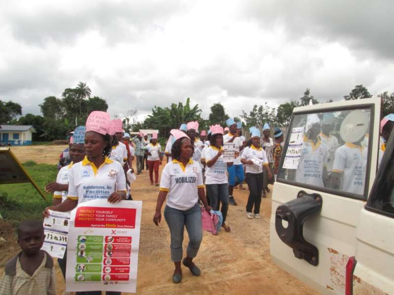 Volunteers go round Bahn Refugee Camp, knocking on doors and advising people to wash their hands as a precaution against the Ebola virus.