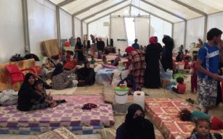 Women wait for their husbands to be security screened before they are allocated individual family tents at Debaga camp in the Kurdistan Region of Iraq.  © UNHCR/Caroline Gluck