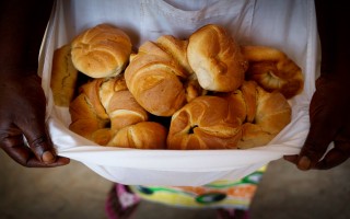 Pascaline holds freshly baked croissants in her apron at Sister Angélique's new bakery.