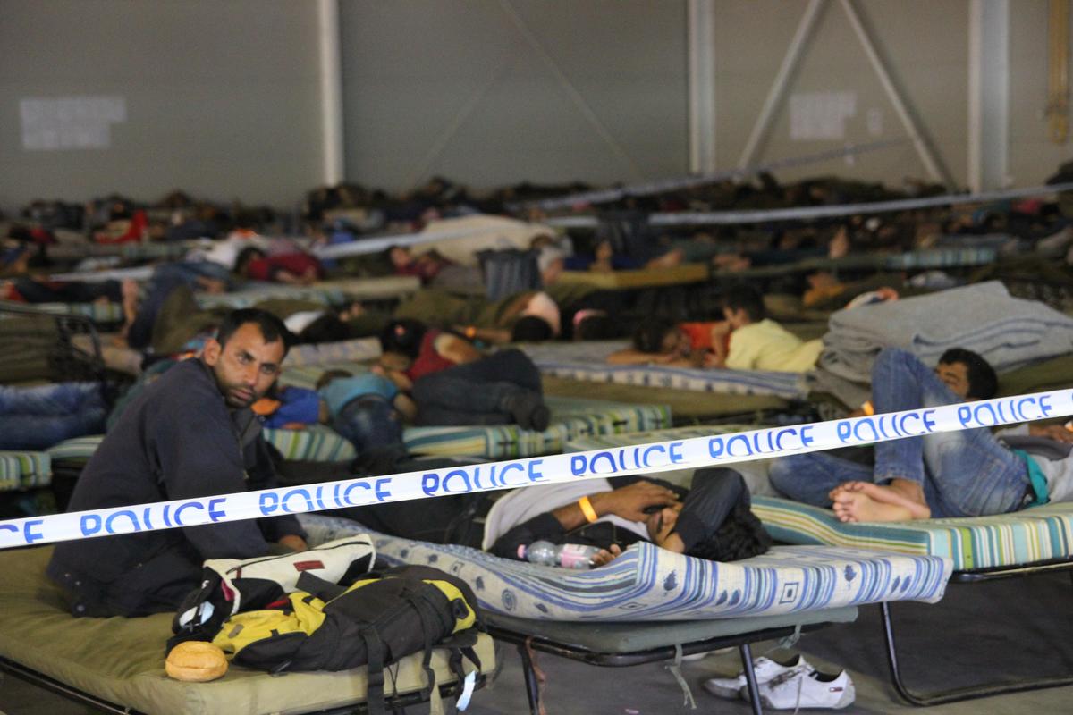 Asylum seekers rest at Roszke police centre in Hungary