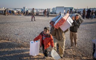 An Iraqi family who fled fighting in Mosul collect aid items at Hasansham camp, Iraq, January 23 2017. They had fled militant held west Mosul three days before by crossing the Tigris River at night in a small wooden boat.  © UNHCR/Ivor Prickett