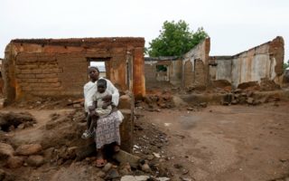 Nigerian returnees sit in front of a house destroyed by Boko Haram in Garaha, Adamawa state, Nigeria in this May 2016 file photo.  © UNHCR/George Osodi