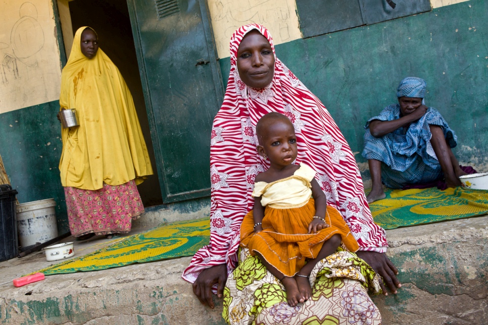 Falmata, 32, rests with her daughter Mamagona in Kuya camp, north-east Nigeria. The 16-month-old girl suffers from malnutrition and is being treated at a small clinic run by the NGO Halima. © UNHCR/Hélène Caux