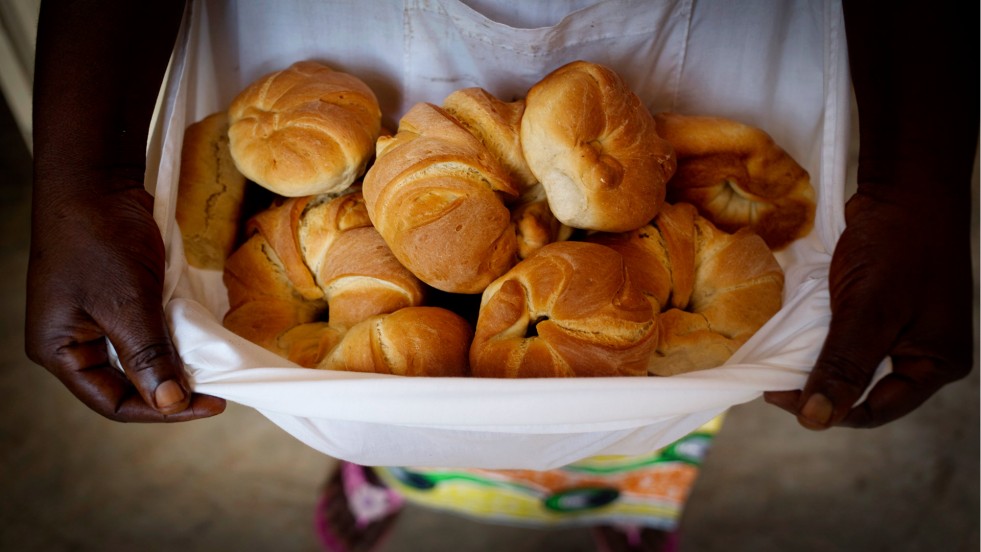 Pascaline tient des croissants frais dans son tablier à la nouvelle boulangerie de soeur Angélique. 