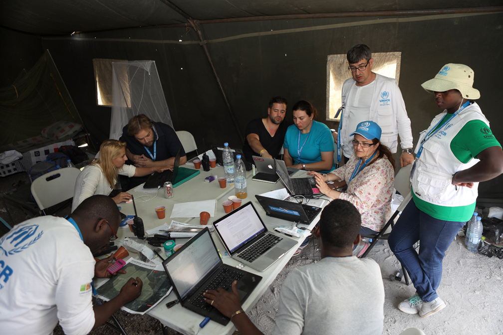 Alpha team works on a plan to respond to a refugee influx and set up a camp with basic services including shelters, toilets, access to clean water, health structures, etc.  © UNHCR / Helene Caux
